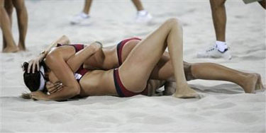 Amerikaanse beachvolleybalsters Kerri Walsh (onder) en Misty May (boven) na het verslaan van de Braziliaanse dames in de finale beachvolleyball tijdens de Olympische Spelen in Athene: Sex on the beach?